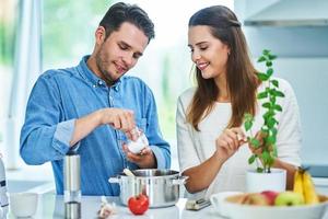 pareja adulta cocinando juntos en casa foto