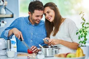 pareja adulta cocinando juntos en casa foto