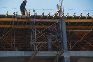 Dnepropetrovsk, Ukraine - 02.23.2022 A worker prepares formwork for a modern metal-concrete structure of a residential building. photo