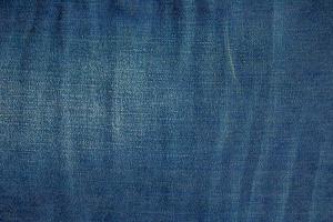 Blue denim background. Texture of classic frayed jeans photo