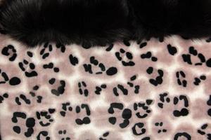 Close-up pattern of fleece fabric with leopard pattern. Brown-beige and black striped repeating on the surface of fur clothes, abstract texture background. photo