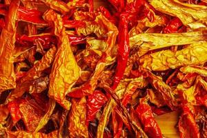 Background of dried organic red capsicum kappia sweet bell pepper chips, paprika and fresh pepper slices. The concept of healthy eating. photo