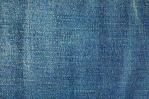 Blue denim background. Texture of classic frayed jeans photo