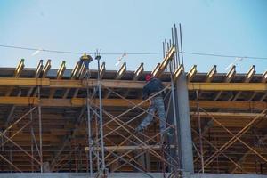 A worker prepares formwork for a modern metal-concrete structure of a residential building. photo