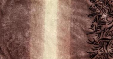 Close-up pattern of fleece fabric. Shades of beige on the surface of fur clothes, abstract texture background. photo