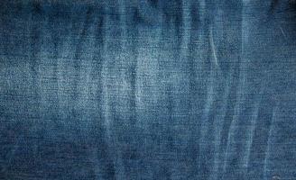 Blue denim background. Texture of classic frayed jeans photo
