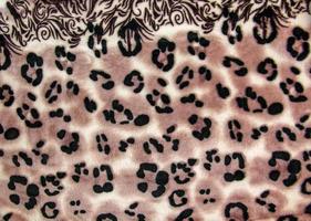 Close-up pattern of fleece fabric with leopard pattern. Brown-beige and black striped repeating on the surface of fur clothes, abstract texture background. photo