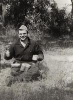 Photo of a young cadet in military uniform during a field lunch at a military exercise.