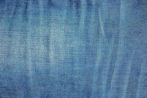 Blue denim background. Texture of classic frayed jeans photo