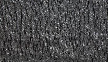 Black textured crinkled background. Black wrinkled fabric with lace inserts. photo