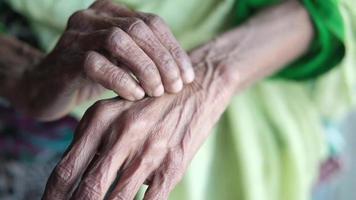 stänga upp händer av äldre kvinna kliar sig tillbaka av hand video