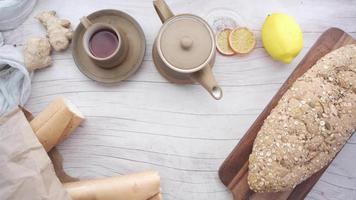 Tea ginger lemons and bread on wood table top video