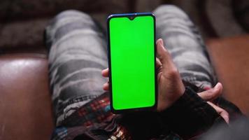 homem usa um telefone inteligente com tela verde video