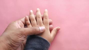 Adult hand holds hand of child video