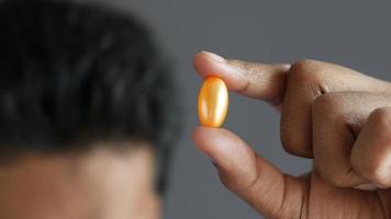 Man holds gel pill capsule between fingers video