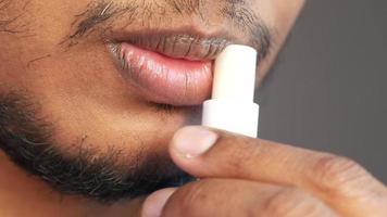 Man applying lip moisturizer