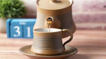 Pouring hot tea from pot to cup video