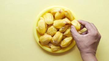 A bowl with small yellow fruit, fresh dates video