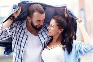 pareja feliz corriendo bajo la lluvia en la ciudad foto