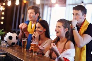 Group of friends watching soccer in pub photo