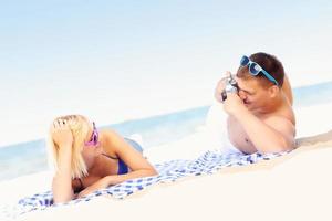 Young couple taking pictures at the beach photo