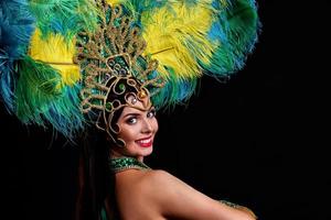 mujer brasileña posando en traje de samba sobre fondo negro foto