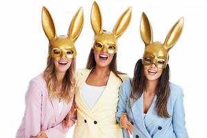 Three women in pastel suits bunny posing over white background photo