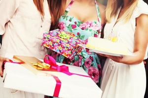 Midsection of women holding birthday cake and presents photo