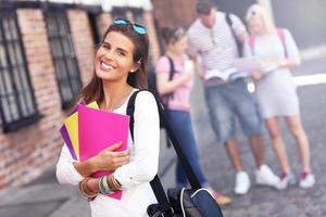 Group of happy students studying outdoors photo