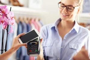 Closeup mid section of female customer paying in shop with credit card photo