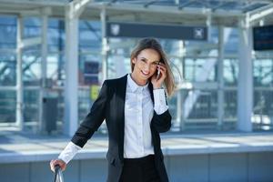 Elegant woman walking with bag and suitcase in the railway station photo