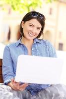 Young woman in the park with laptop photo