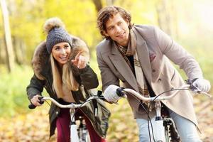 pareja feliz en bicicleta en el bosque durante el otoño foto