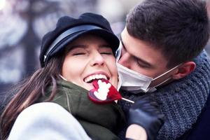 Happy couple celebrating Valentines Day in masks during covid-19 pandemic photo