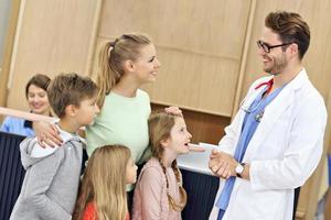 Mother and children together in hospital with doctor photo