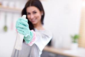 Beautiful young woman cleaning the kitchen photo