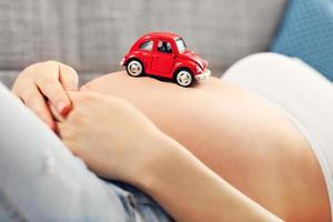 Happy pregnant woman resting on sofa photo