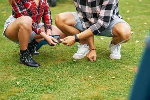 Young nice couple having fun on camping setting up tent photo