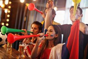 Group of friends watching soccer in pub photo