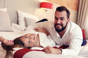 Adult couple in business outfit lying on hotel bed photo