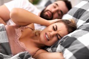 Adult couple suffering from snoring problem in bed photo