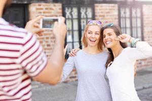 grupo de amigos felices tomando fotos en la ciudad