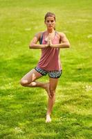 mujer joven haciendo yoga en el parque foto