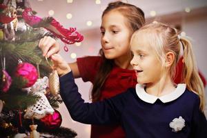 niños decorando arbol de navidad foto