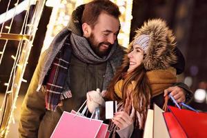 pareja adulta de compras en la ciudad durante la época navideña foto