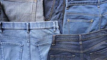 varios tonos azules y tamaños de pares de jeans de mezclilla en la parte posterior foto