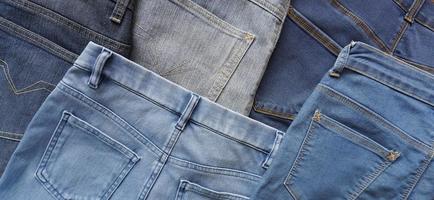 varios tonos azules y tamaños de pares de jeans de mezclilla en la parte posterior foto