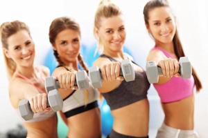 Group of smiling people lifting barbells photo