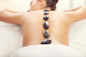 Beautiful woman getting stone massage in spa photo