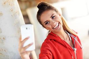 Woman jogging on the beach with smartphone photo